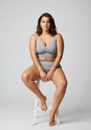 Confident Plus Size Woman Sitting on Chair in Casual Gray Outfit
