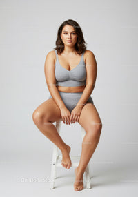 Confident Plus Size Woman Sitting on Chair in Casual Gray Outfit