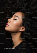 Calm woman with closed eyes and flowing curly hair