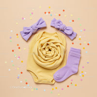 Yellow Baby Onesie with Lilac Accessories and Confetti
