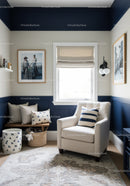 Modern Cozy Reading Corner with Navy Blue Wall Panels and White Armchair