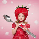 Little girl in strawberry hat holding giant spoon