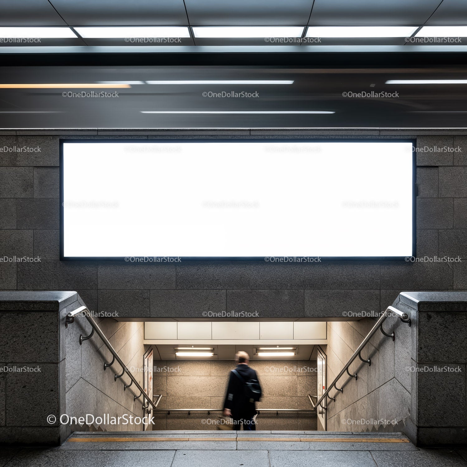 Mężczyzna schodzący po schodach metra pod pustym billboardem