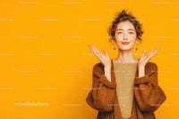 Cheerful Young Woman with Curly Hair in Warm Sweater on Yellow Background
