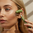 Close Up of Green Jade Roller on Woman's Cheek for Facial Rejuvenation