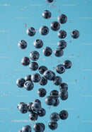 Fresh blueberries suspended in clear water droplets