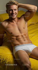 Smiling young man relaxing on yellow bed in white underwear