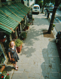 Smiling Woman Standing on City Sidewalk with Flanking Flower Pots