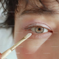 Close-Up of Woman Applying Eye Makeup with Shimmering Eyeshadow
