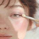 Close-Up of Young Woman Applying Pink Eyeshadow with Brush