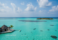 Turquoise Ocean with Overwater Bungalows and Palm Trees at Paradise Island