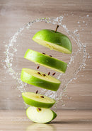 Fresh green apple slices suspended in water splash