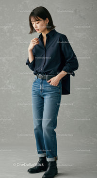 Stylish Woman in Casual Jeans and Black Shirt Against Neutral Background