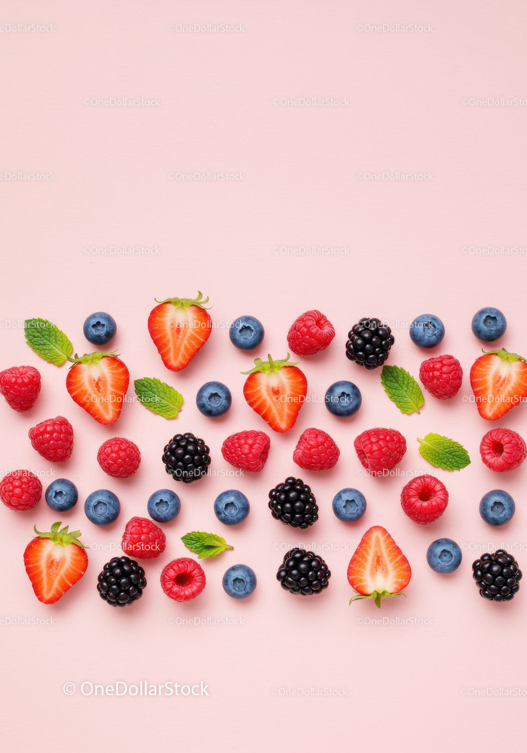 Fresh Mixed Berries with Mint Leaves on Pink Background