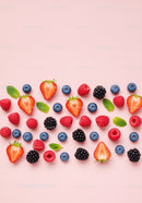 Fresh Mixed Berries with Mint Leaves on Pink Background