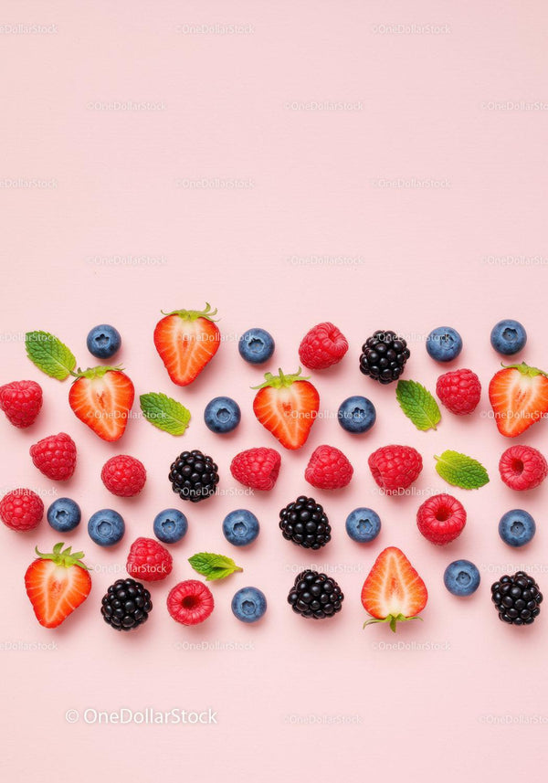 Fresh Mixed Berries with Mint Leaves on Pink Background