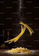 Dry pasta with flour falling on wooden table