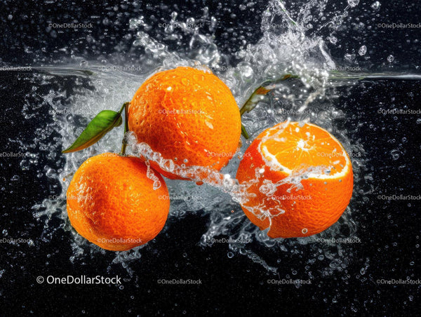 Fresh Orange Slices and Whole Oranges Splashing in Water