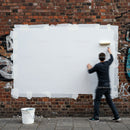 Person Rolling White Paint on Brick Wall Mural Space