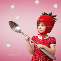 Little girl in strawberry hat holding giant spoon