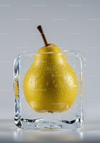 Yellow pear frozen inside a clear ice cube