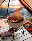 Hearty stew cooking on portable stove at mountain camp