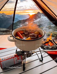 Hearty stew cooking on portable stove at mountain camp