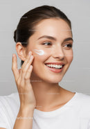 Young Woman Applying Facial Cream for Glowing Skin