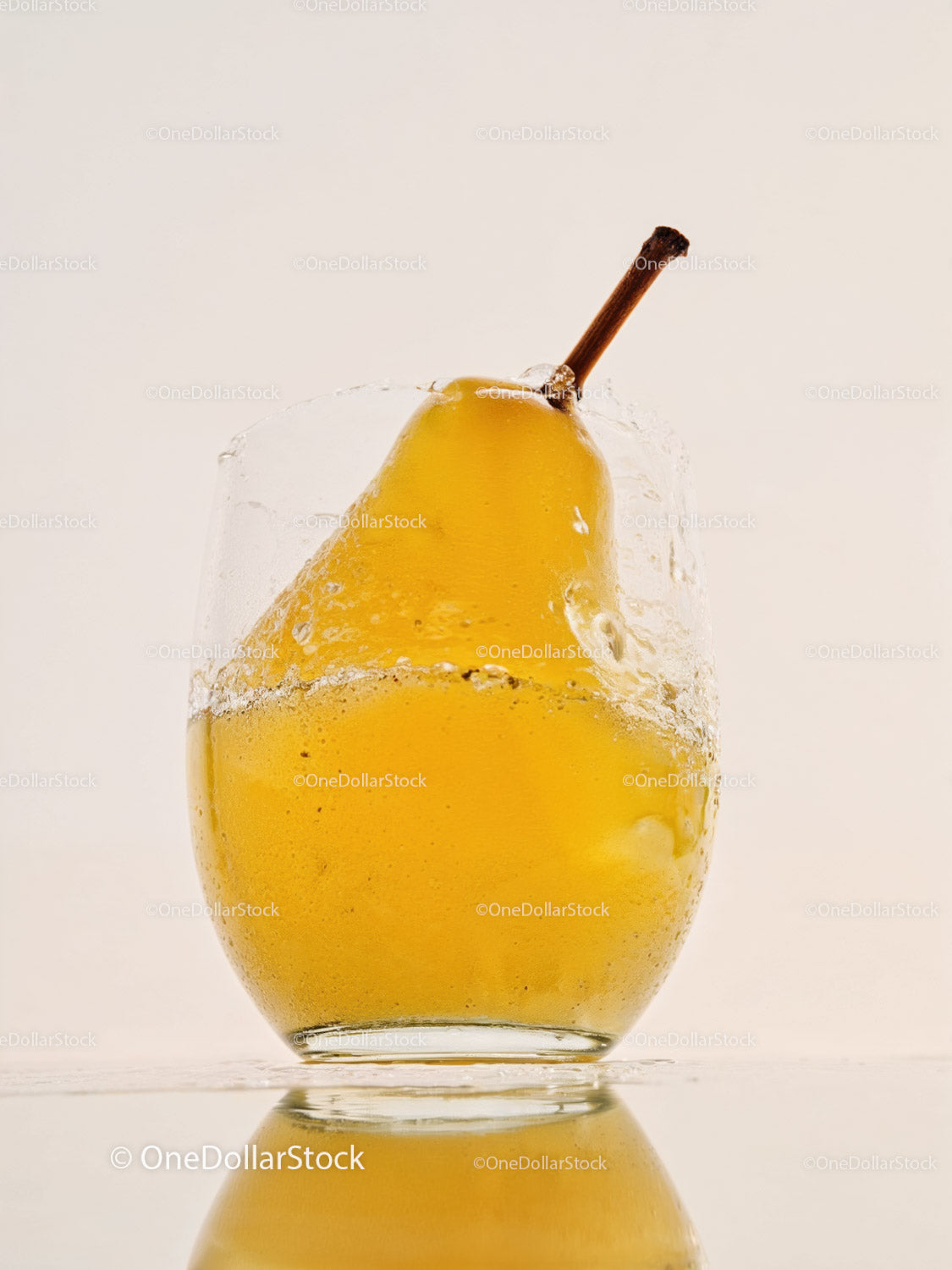 Fresh pear splashing into clear water glass