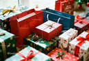 Colorful wrapped Christmas gifts piled with festive bags