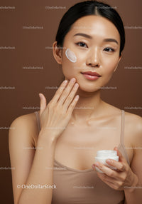 Woman Applying Moisturizer on Face in Beauty Routine Shot