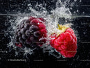 Juicy Black Grapes and Red Raspberries Splashing in Water