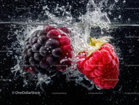 Juicy Black Grapes and Red Raspberries Splashing in Water