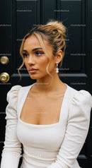 Elegant woman with blonde hair in white dress by door