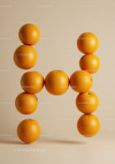 Floating Oranges Arranged in Letter H on Beige Background