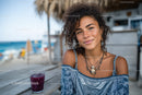 Young Woman Enjoying Summer at a Beachside Cafe with Glass of Juice