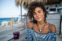 Young Woman Enjoying Summer at a Beachside Cafe with Glass of Juice