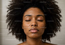 Woman with Curly Hair and Moisturizing Facial Skincare Routine