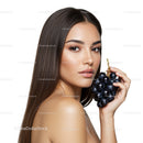 Elegant Woman with Long Brown Hair Holding Black Grapes in Studio