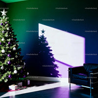 Christmas tree casting star shadow beside modern armchair