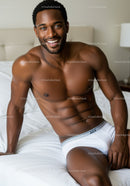 Smiling man relaxing on bed in white underwear