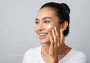 Young Woman Applying Facial Cream with Smooth Skin and Radiant Smile
