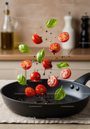 Fresh cherry tomatoes and basil leaves falling into pan