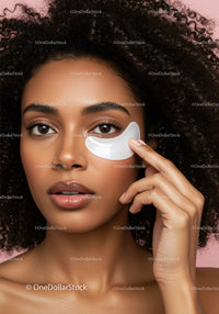 Beautiful woman with curly hair applying eye care patches for skincare