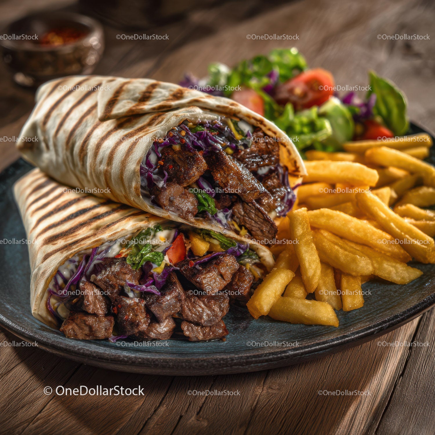 Two Beef Burritos with Fries and Salad on Black Plate