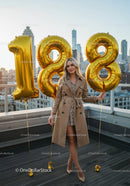 Elegant young woman celebrating 18th birthday with balloons