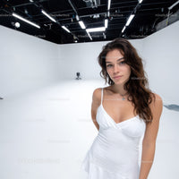 Stylish Young Woman in White Dress Portrait in Modern Studio