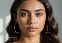 Close-up of a Beautiful Young Woman with Brown Eyes and Hoop Earrings
