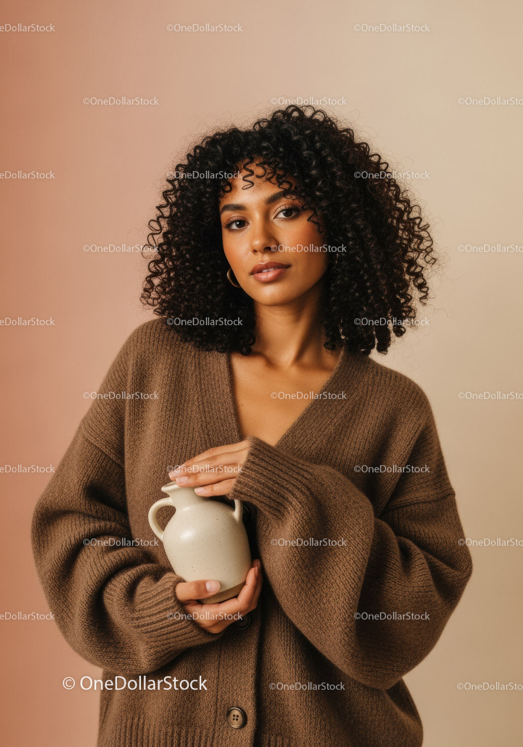 Young Woman with Curly Hair Holding Vase in Cozy Brown Sweater