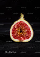 Close up of fresh ripe fig half on black surface